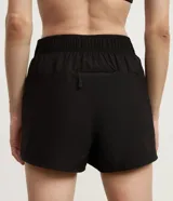 Bermuda deportiva Get Over modelo runner color beige, con cintura elástica, bajo redondeado y aberturas laterales. Cuenta con un pequeño bolsillo funcional trasero.