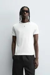 Camiseta gris de corte slim fit, confeccionada en tejido de algodón con elasticidad, cuello redondo y manga corta.