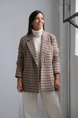Blazer de corte recto con estampado a cuadros en tonos beige y marrón, con solapas clásicas y cierre frontal.