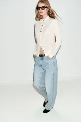 Jeans de tiro medio, corte loose straight, color celeste claro con efecto de salpicaduras de pintura en varios colores. Cierre frontal con cremallera y botón, y diseño de cinco bolsillos.