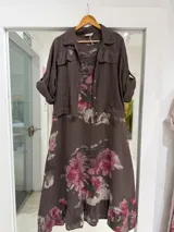 Conjunto compuesto por un vestido midi sin mangas con estampado floral en tonos rosados sobre base marrón, y una casaca o chaqueta liviana marrón de manga larga con bolsillos en el pecho y cierre de botones.