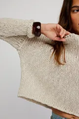 Sweater de punto grueso color beige, de calce amplio y largo corto, con escote redondo, mangas caídas y terminaciones acanaladas en tejido abierto.