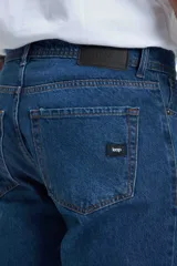 Pantalón de jean azul de corte recto, con tiro medio y cierre con botones.