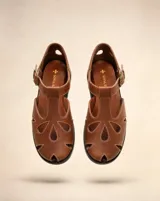 Sandalia de cuero color marrón, estilo romano, con puntera semi cerrada, calados orgánicos en la capellada y pulsera regulable con hebilla metálica.