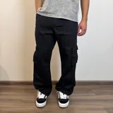 Pantalón jean cargo gris con efecto lavado, corte recto y bolsillos laterales.