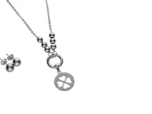 Set de collar y caravanas plateados de acero. El collar tiene una cadena de eslabones, cuentas esféricas y un dije circular con un trébol de cuatro hojas calado. Las caravanas son esferas lisas.