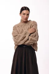 Sweater de tejido de punto grueso con diseño de rombos en relieve, cuello redondo y mangas largas amplias. Presenta una silueta relajada y holgada.