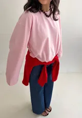 Remera oversize rosada de manga larga y ancha, con cuello redondo y diseño holgado.