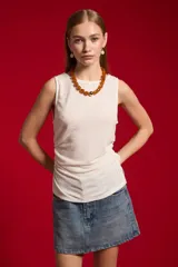 Musculosa blanca sin mangas de poliéster, con cuello bote y diseño ajustado al cuerpo.