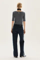 Jean recto de tiro medio, color azul oscuro, con franja lateral de tela gris más clara. Presenta un efecto de textura sutil en la tela principal.