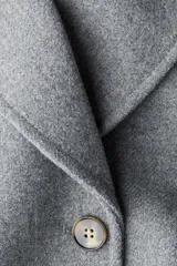 Abrigo cruzado de largo hasta la rodilla, confeccionado con lana. Presenta solapas de muesca, cierre frontal con doble botonadura, bolsillos delanteros insertados, trabillas con botón en los puños y abertura trasera. La prenda se encuentra totalmente forrada.