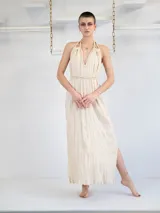 Vestido largo color crema con breteles finos regulables que se atan al cuello, escote en V con detalle trenzado y cintura ajustable.