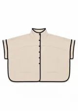 Poncho de corte amplio color beige con cuello alto, cierre frontal con botones y ribetes en contraste color negro. Presenta dos bolsillos frontales tipo parche y mangas cortas integradas.
