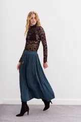 Falda larga de poliéster color azul petróleo, con cintura elastizada tipo nido de abeja, lazos de ajuste con terminales metálicas y tajo lateral.