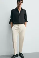Pantalón regular fit color negro de tejido con viscosa, con cintura elástica ajustable con cordón, bolsillos frontales y traseros.