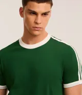 Remera de algodón color celeste con cuello redondo y bordes de mangas en color blanco. Presenta diseño de rayas dobles blancas en los hombros y mangas.