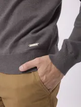 Sweater de punto color gris, con cuello polo y cierre frontal parcial, de manga larga y ajuste regular.