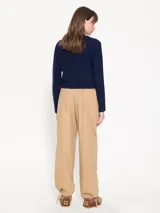 Babucha color beige confeccionada en gabardina lisa, con bolsillos cargo. Tiene ajuste de lazo en la cintura y en el ruedo.