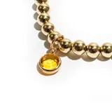 Pulsera dorada con cuentas esféricas y dije colgante de cristal facetado color amarillo.