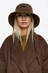 Gorro tipo bucket color marrón, confeccionado en algodón, con logo de la marca bordado en negro y cordones laterales ajustables.