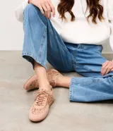 Championes de diseño bajo color tostado, con paneles laterales y superiores de encaje floral semitransparente, combinados con recortes de material sintético y cierre de cordones al tono.