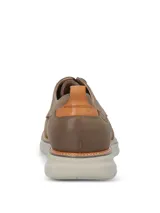 Zapato de estilo casual Hush Puppies, confeccionado en cuero color taupe. Presenta cierre mediante cordones, detalle de tirador en el talón y suela de EVA con tecnología FLX que brinda mayor flexibilidad y confort.