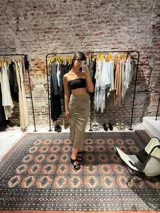 Pollera midi de satén color beige, con diseño de frunces laterales y tajo frontal.