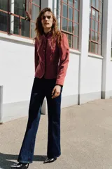 Blazer de terciopelo con cuello subido y manga larga. Presenta cierre frontal con botones, bolsillos de vivo en el delantero y detalle de vivo a contraste en los bordes.