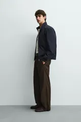 Cazadora de corte regular fit confeccionada en tejido técnico repelente al agua. Presenta cuello subido, cierre frontal de cremallera, bolsillos laterales de vivo y acabados en rib en puños y bajo.