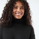 Vestido corto de punto color negro, con cuello alto y mangas largas, de corte recto y ajuste cómodo.