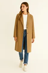 Tapado de corte recto y largo medio, color tostado, con solapas clásicas, cierre frontal de dos botones y bolsillos laterales.