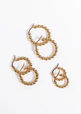 Par de aros dorados tipo argolla, con esferas pequeñas a lo largo de todo el aro.