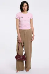 Remera baby tee de corte cropped y ajuste al cuerpo, color rosa con ribetes blancos en cuello y mangas. Presenta estampa frontal con el número 10, el año 94 y la frase 'GAME OVER' repetida tres veces.