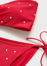 Top de bikini bandeau color fucsia con apliques metálicos y cierre trasero.