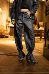Jean de tiro medio con silueta relajada, pierna amplia y volumen curvo. Presenta un diseño con cintura de efecto superpuesto y bajos extendidos con cordones para ajustar. Confeccionado en denim con proceso de encuerado.