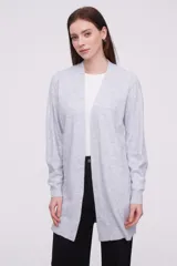 Saco abierto de punto, color gris claro, con diseño holgado y mangas largas.