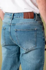 Pantalón de jean azul oscuro, corte recto y relajado, con cintura estándar y bolsillos delanteros y traseros.