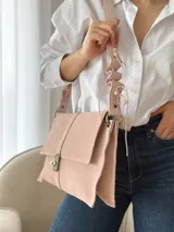 Bandolera de cuero color beige claro, con solapa frontal, cierre metálico de broche y correa regulable con detalles ondulados.
