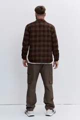 Pantalon cargo de corte holgado en color marrón, con bolsillos laterales con solapa y cierre frontal.