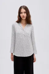Blusa de viscosa color bordó, con cuello en V, cierre frontal parcial con botones, mangas tres cuartos y bolsillo aplicado en el pecho.