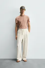 Camiseta de algodón con cuello redondo y manga corta, confeccionada en tejido jacquard a rayas horizontales en tonos terracota y beige.