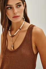 Top de punto color beige, con escote en U pronunciado y textura sedosa y brillante.