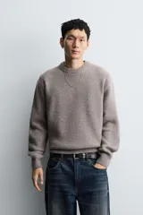 Jersey de punto con textura efecto pelo, corte boxy fit, cuello redondo y manga larga con acabados en rib.