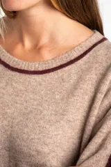 Sweater de tejido de punto con calce oversize, color azul marino con detalles en color marrón en las mangas y cuello. Presenta un diseño de manga larga y puños y ruedo acanalados.