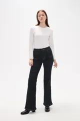 Pantalon de jean azul oscuro con corte flare, tiro alto y bolsillos frontales tipo parche.