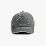 Gorra tipo baseball color negro con efecto lavado, presenta un parche ovalado bordado con la palabra Nude y detalles de desgaste en la visera.