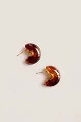 Aros abridores tipo argolla semicircular de resina con efecto carey en tonos marrones y detalles metálicos dorados.