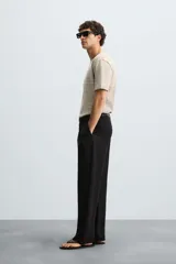 Camiseta de punto de corte relajado (relaxed fit) con cuello redondo y manga corta. Tejido en hilatura de algodón y lino, con rayas horizontales en tonos beige y marrón claro. Los acabados del cuello y los puños son en un tono marrón más oscuro a contraste.