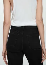 Jeans mom-fit de tiro alto color negro, con diseño clásico de cinco bolsillos, trabillas para cinturón y cierre frontal con cremallera y botón.