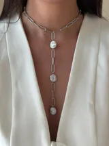 Corbatín con cadena de acero quirúrgico color plateado y perlas de río. Se puede usar ajustado al cuello o más suelto. Se cierra con ganchito para regular el largo.